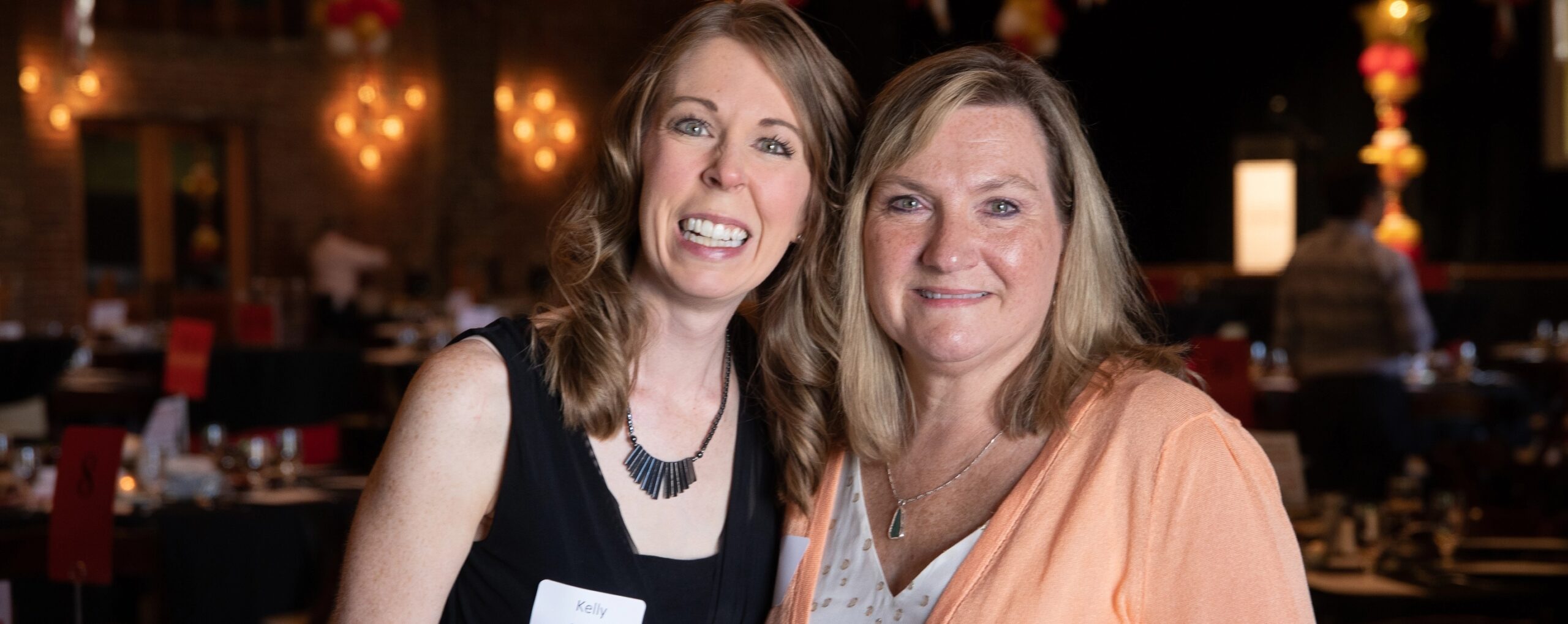 Two women posing for a photo at an event.